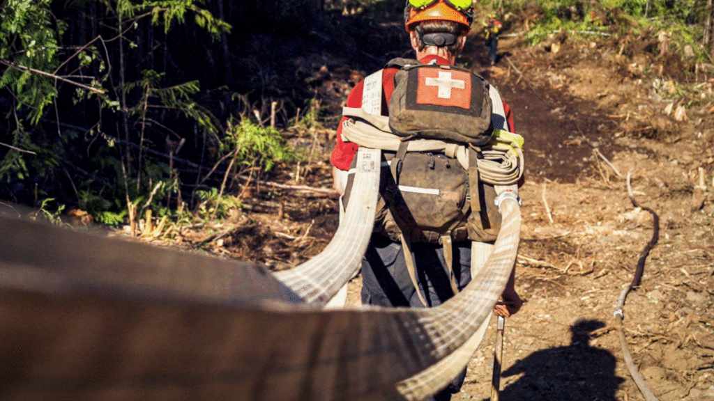 Wildland firefighter moving hoses at Cameron Lake wildfire